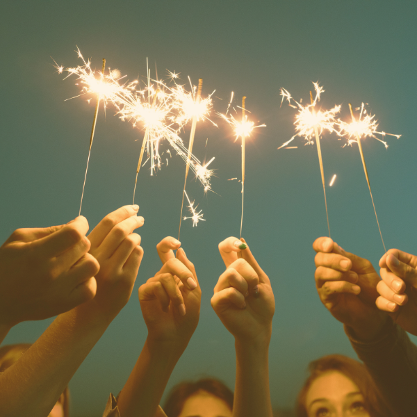 image: several hands, holding up sparklers fireworks. Image symbolizes the celebration of New Year's Day, and the start of Dry January.